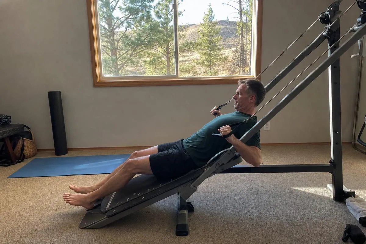 A man rowing on a Total Gym inclined bodyweight home gym